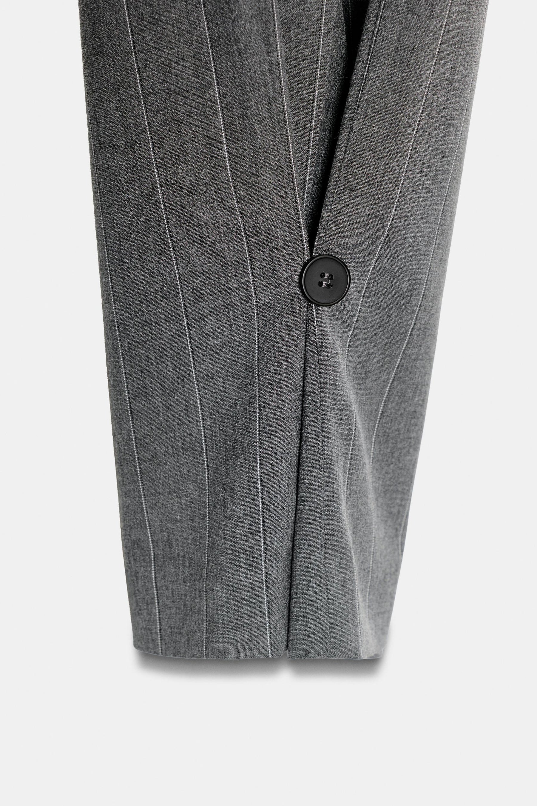 Hose mit Falten und Knopfverschluss am Saum